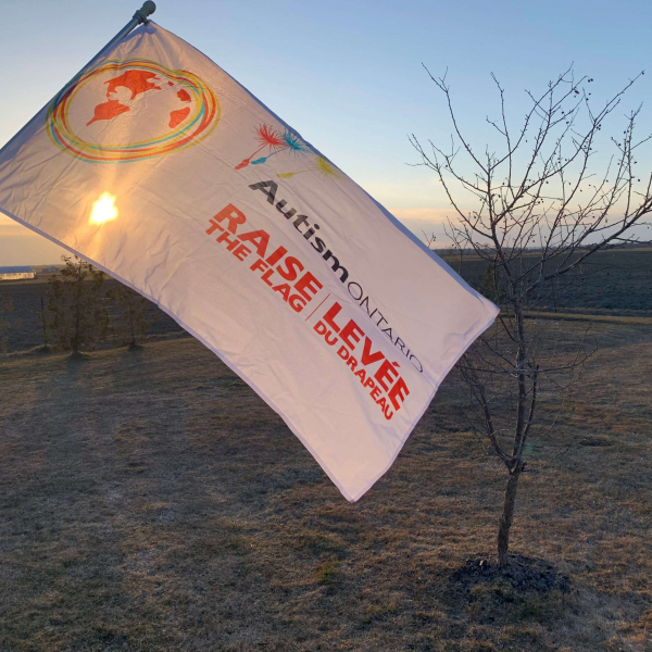 A Raise the Flag flag waving in front of a sunset
